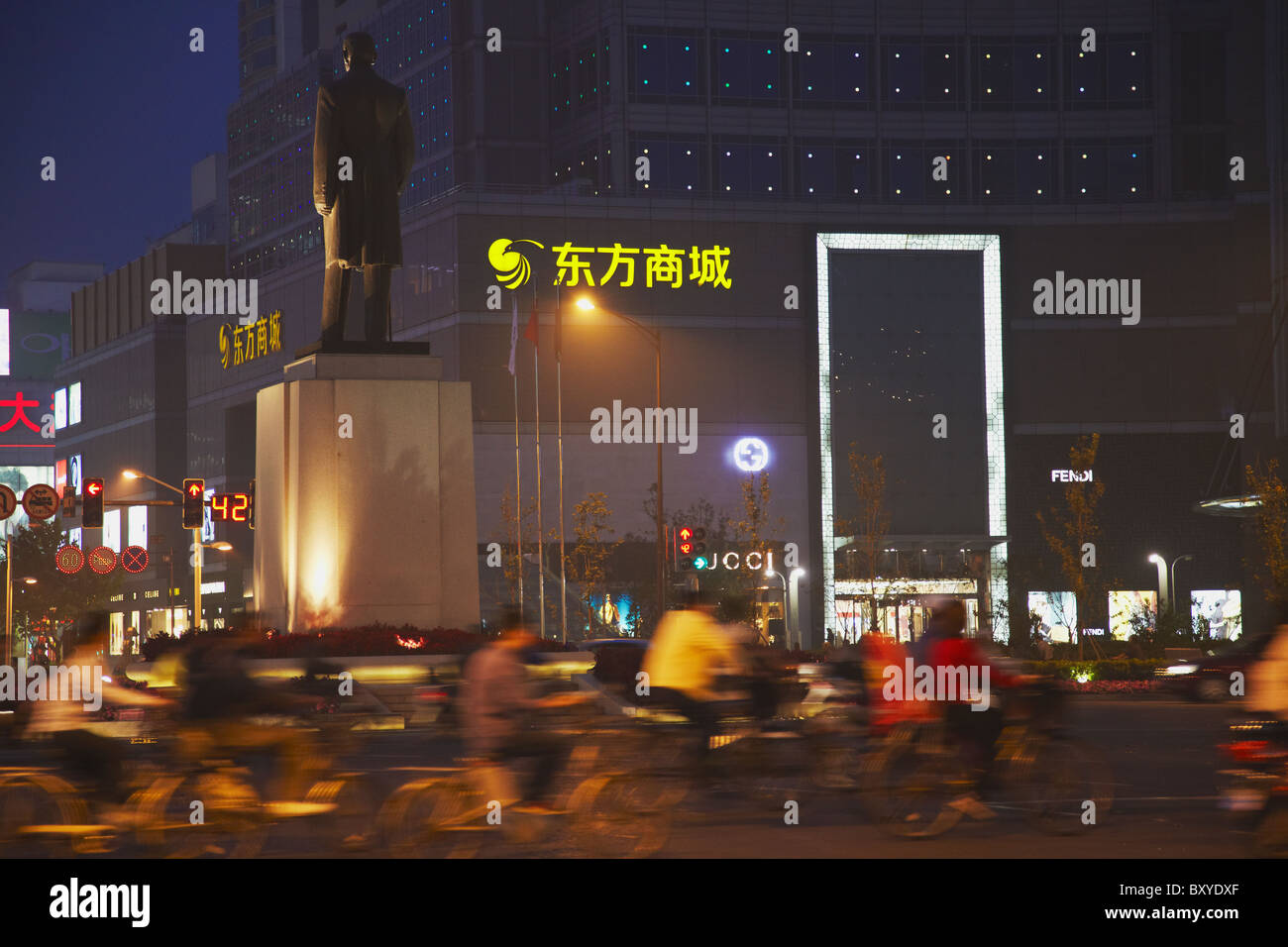 Cyclists passing statue of Sun Yat Sen, Xinjiekou, Nanjing, Jiangsu, China Stock Photo