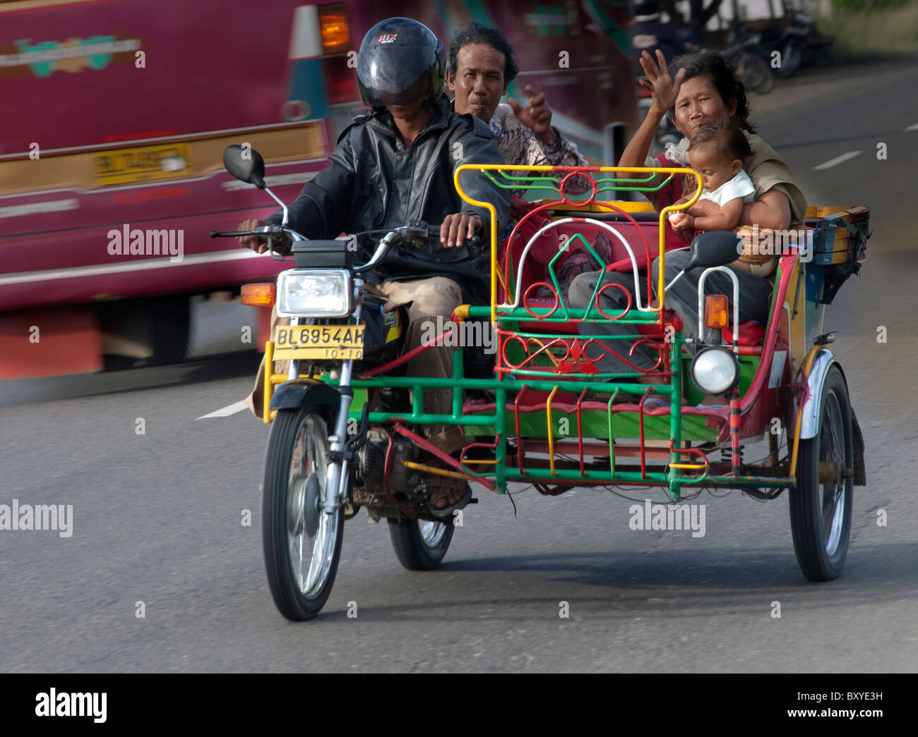 Family travel by motorbike taxi, Indonesia Stock Photo