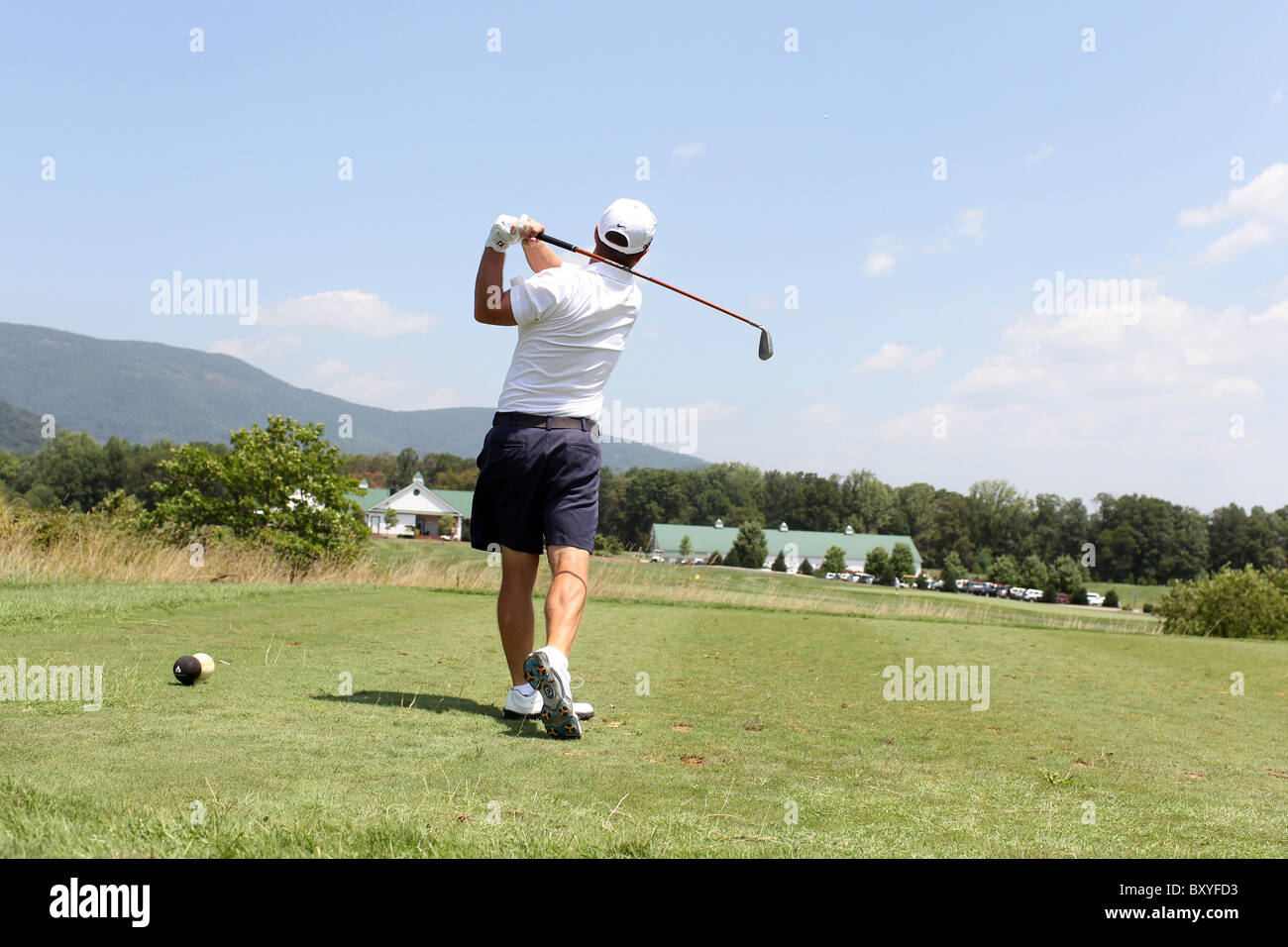 Golfer tees off at a local golf course in Charlottesville, VA. Stock Photo
