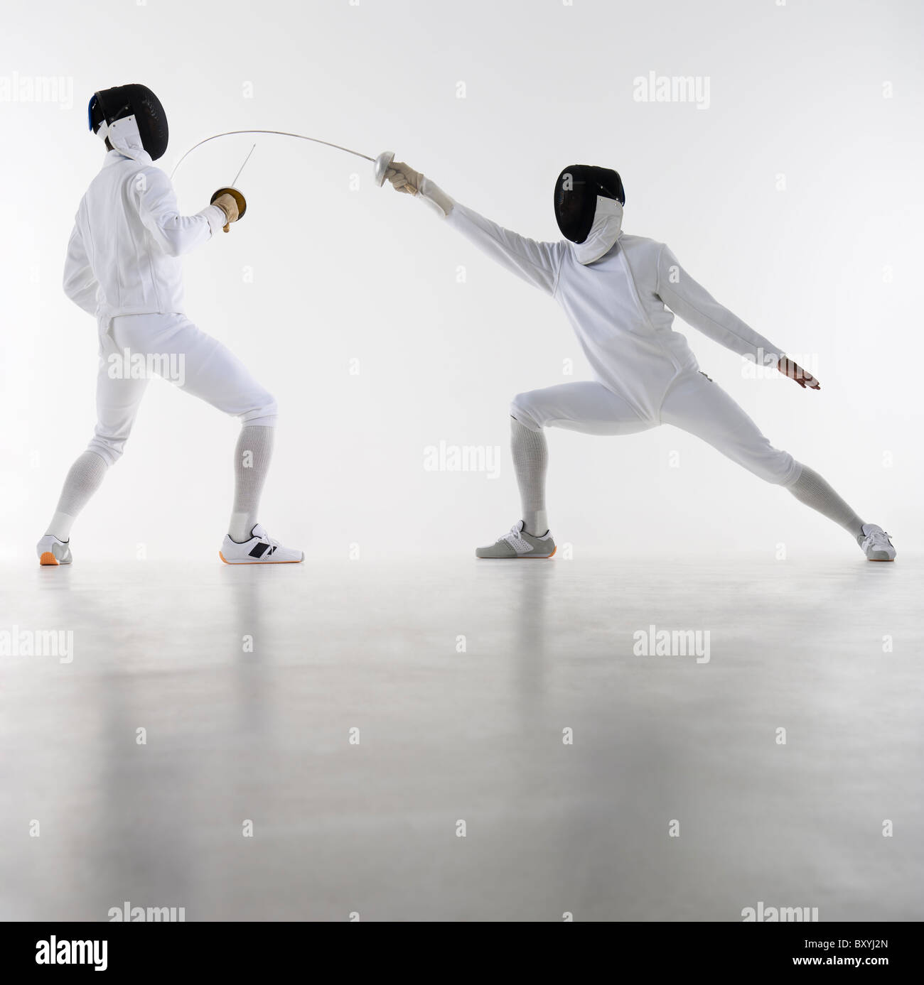Studio shot of fencers in attacking lunge Stock Photo