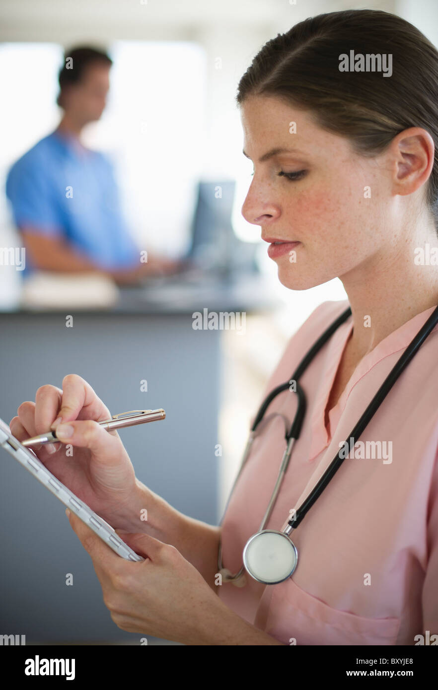 Female doctor writing documentation in hospital Stock Photo - Alamy