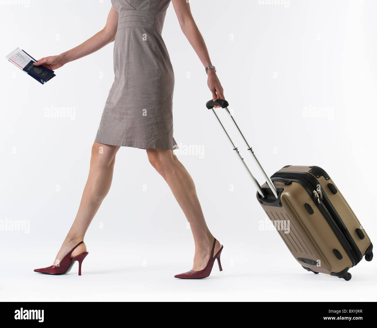 Young woman with suitcase, studio shot Stock Photo