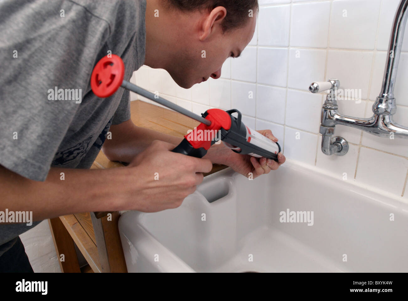 Man using sealant gun in a kitchen Stock Photo Alamy