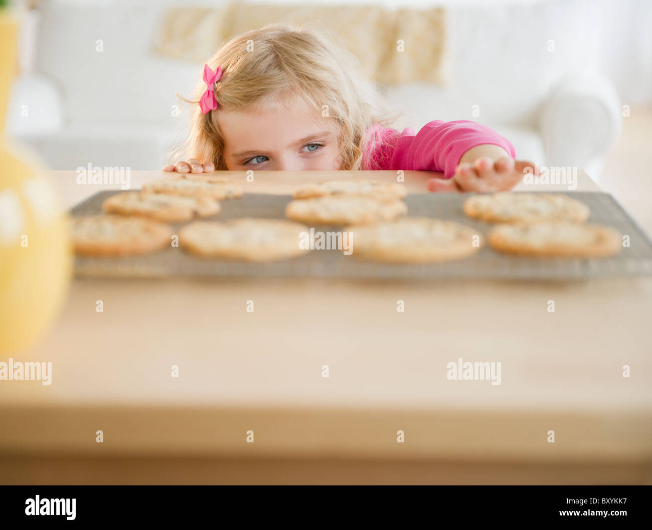 Girl reaching for biscuits Stock Photo