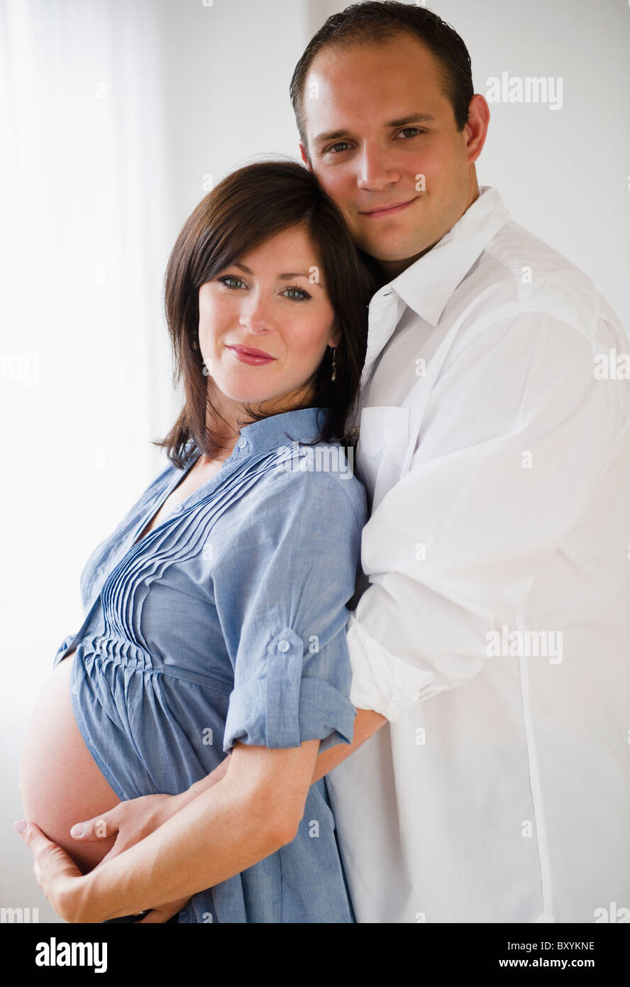 Young man hugging pregnant woman Stock Photo - Alamy