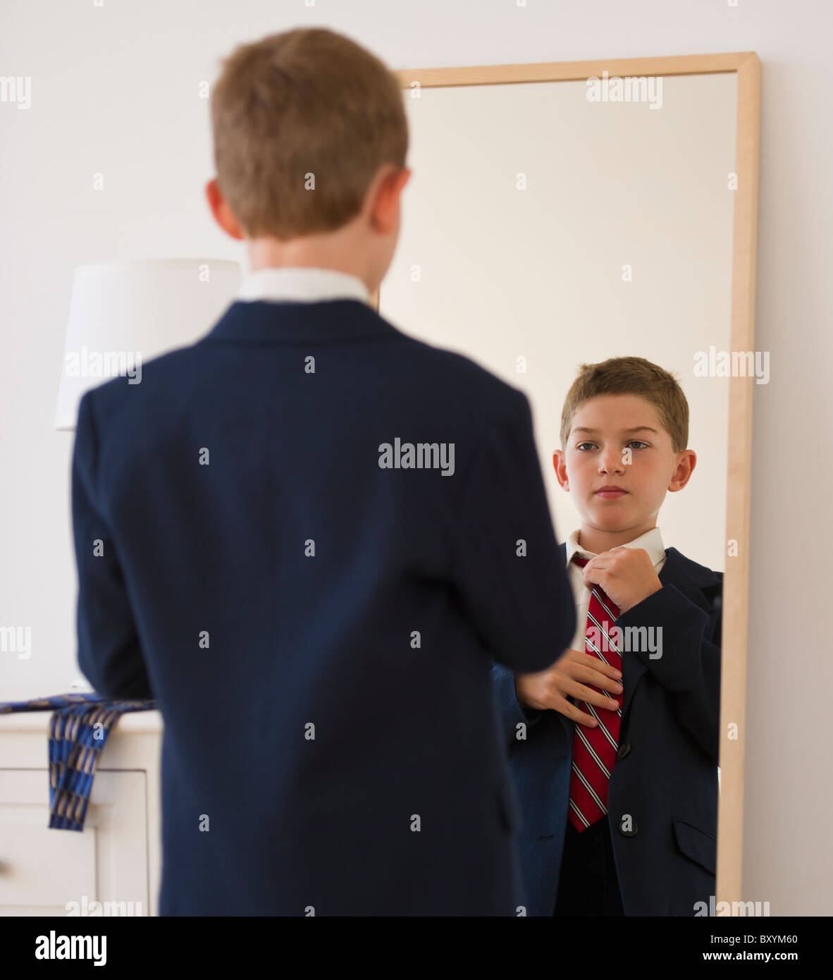 Boy adjusting tie in front of mirror Stock Photo Alamy