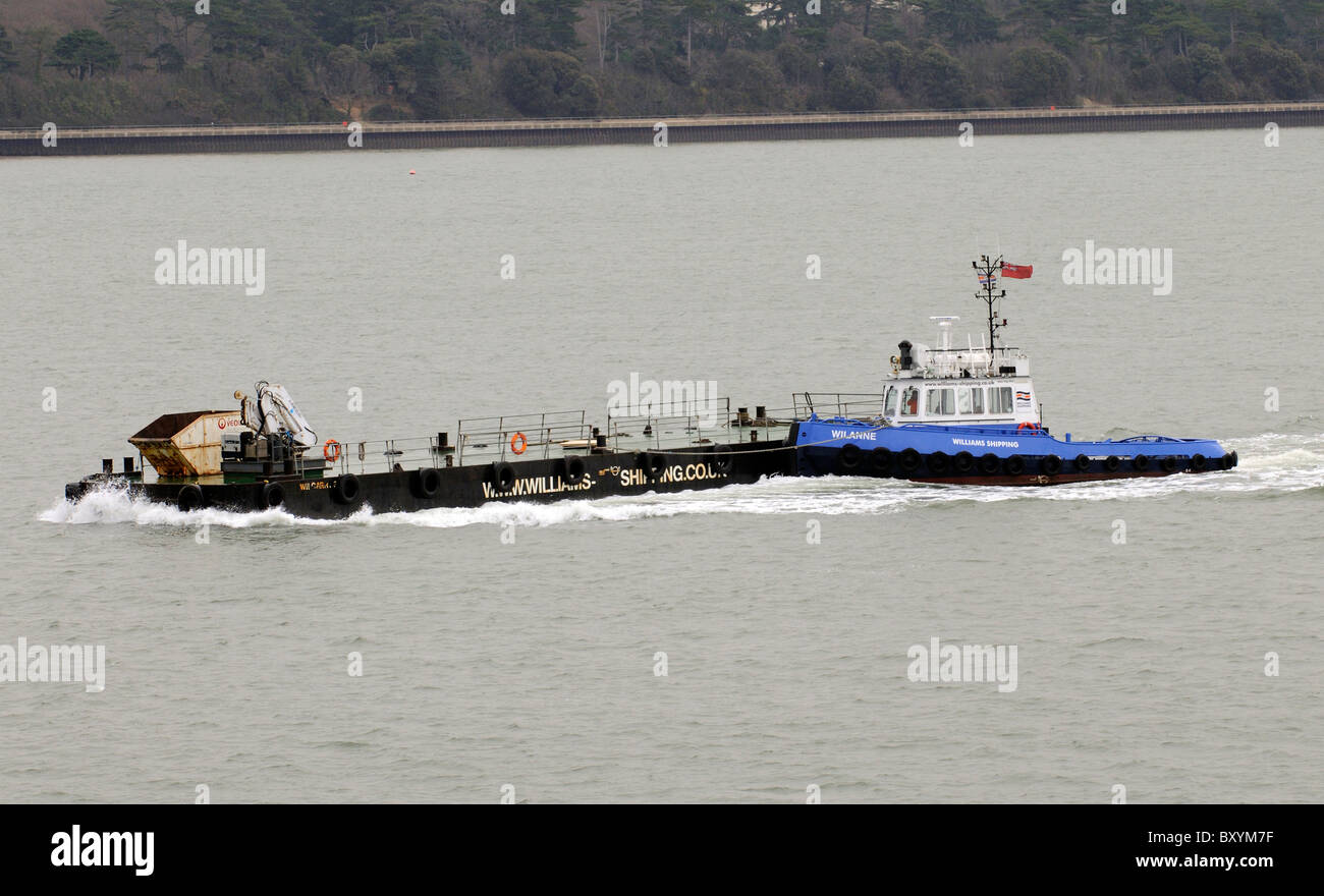The Wilanne a Damen Stantug tug and workboat pushing a barge on Southampton Water England UK Stock Photo