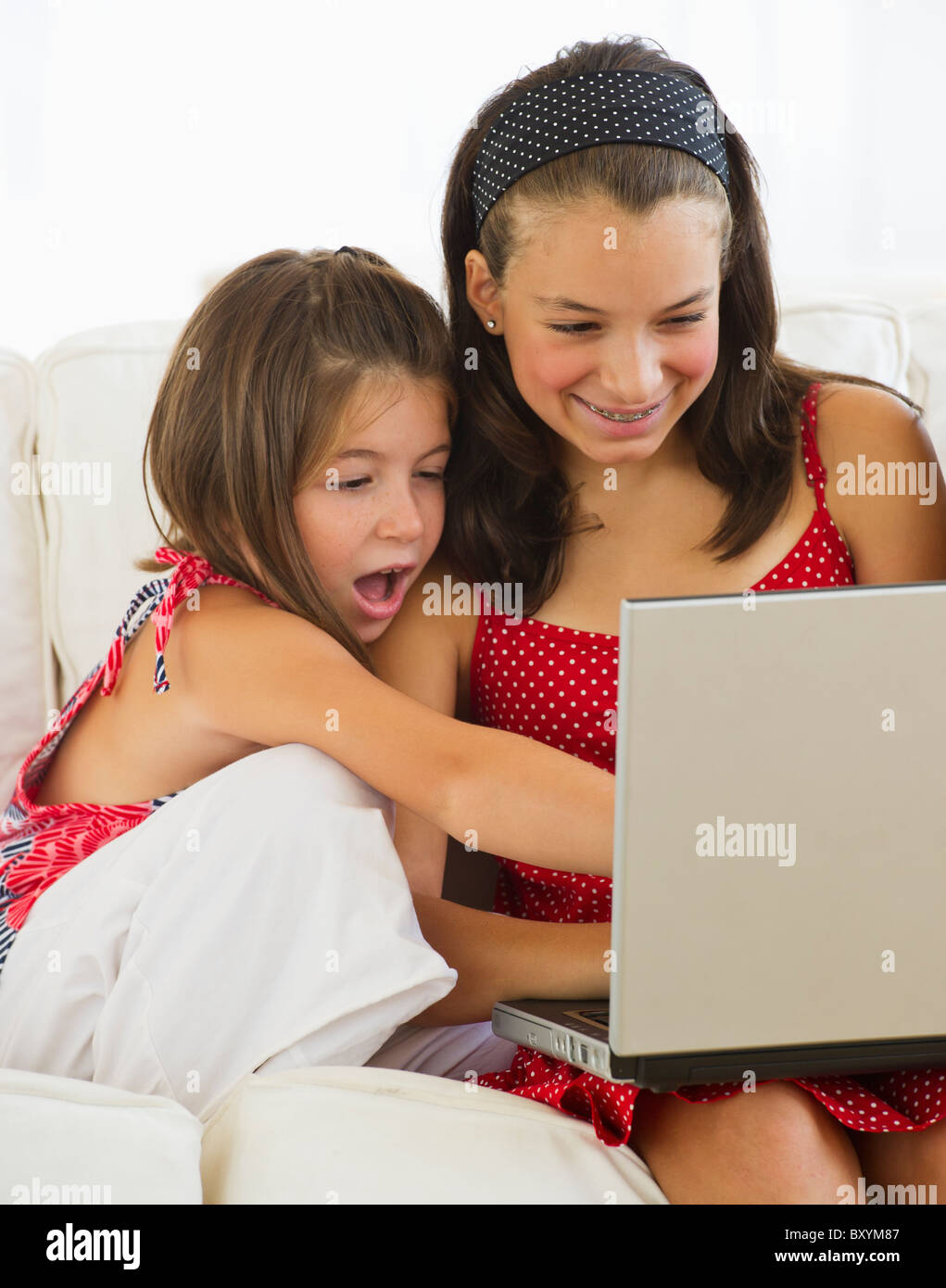 Sisters using laptop together Stock Photo - Alamy