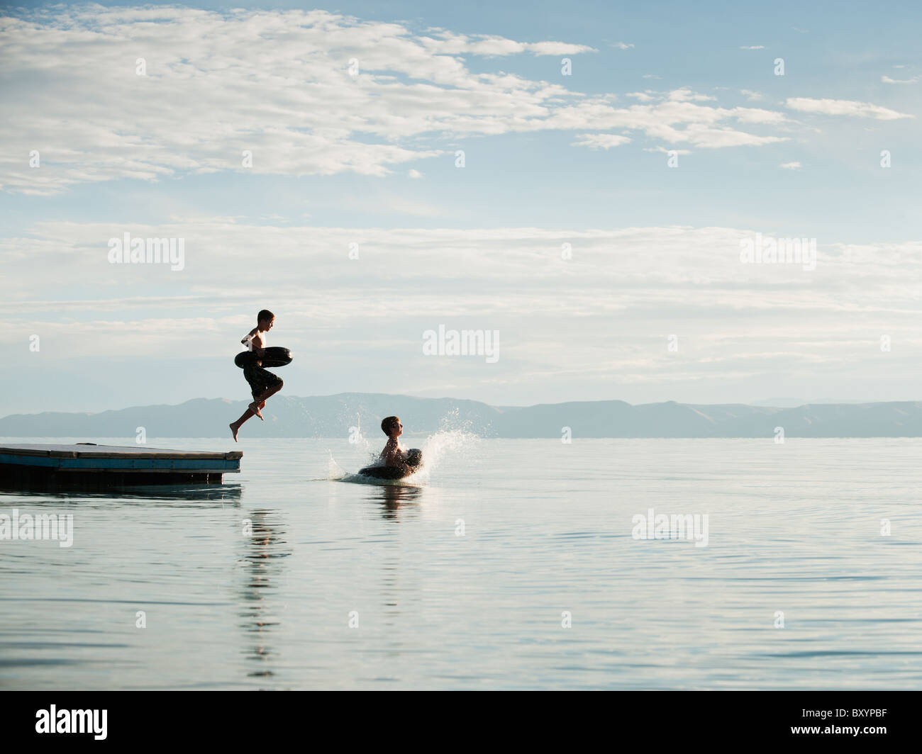 Boys jumping from raft Stock Photo - Alamy