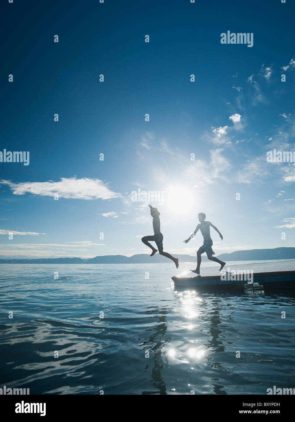 Boys jumping from raft Stock Photo - Alamy