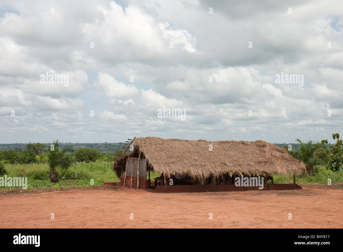 A thatch roof hut in a West African village is the venue for these students to receive their education. Stock Photo