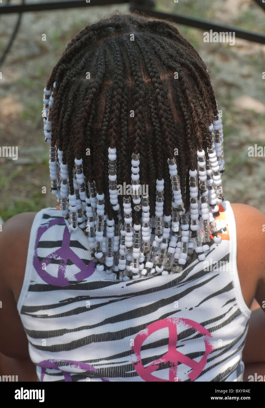 Pioneer Days Festival High Springs Florida.  Young girl with fancy hair cornrows and wearing a shirt decorated with peace  symbols. Stock Photo