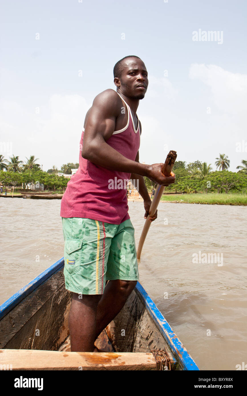 A man oars across Lac Togo on the way from Togoville in a traditional canoe. Stock Photo