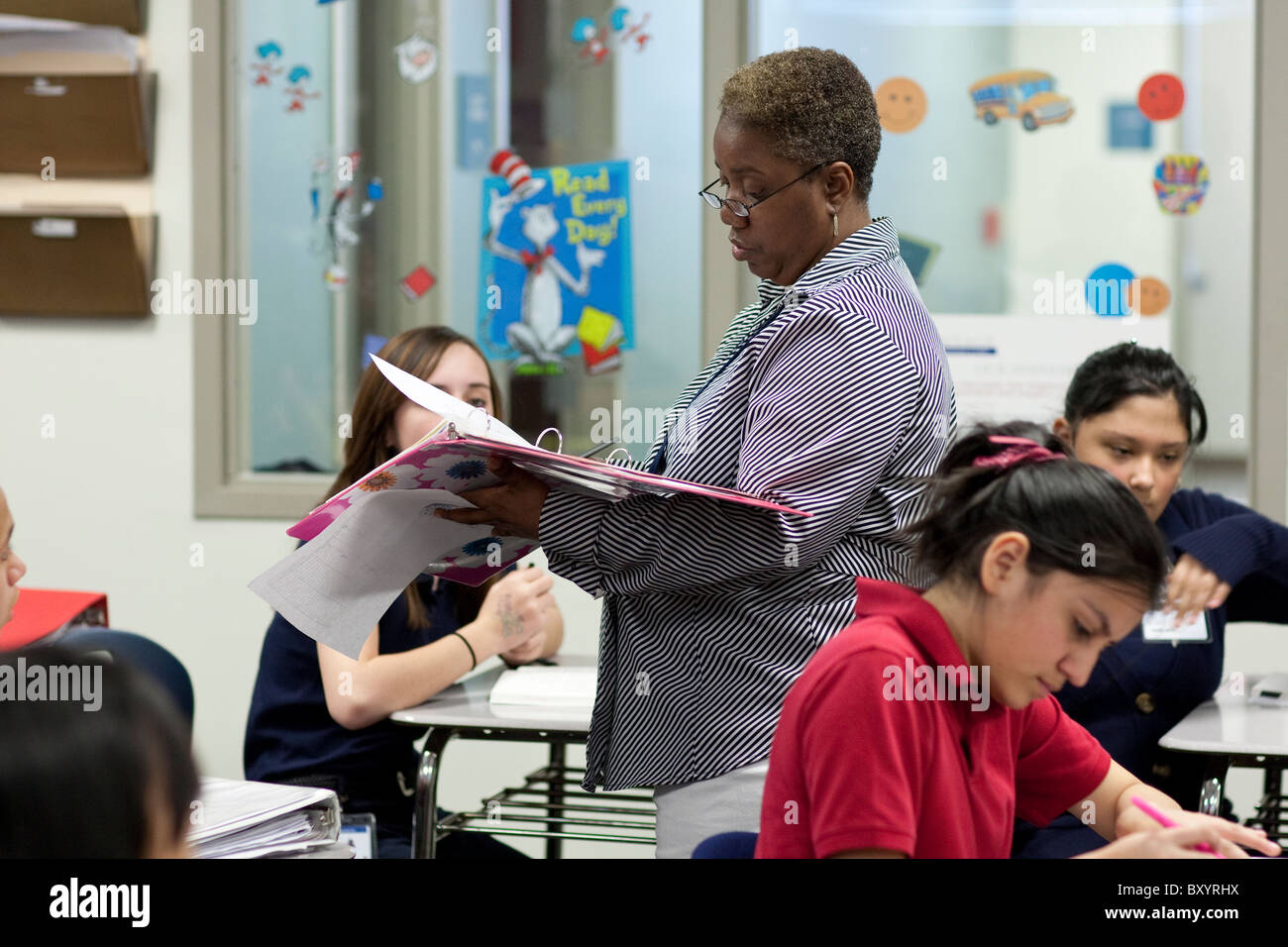 Female African American teacher checks student's work at Peak Preparatory Academy public charter school in Dallas, Texas Stock Photo