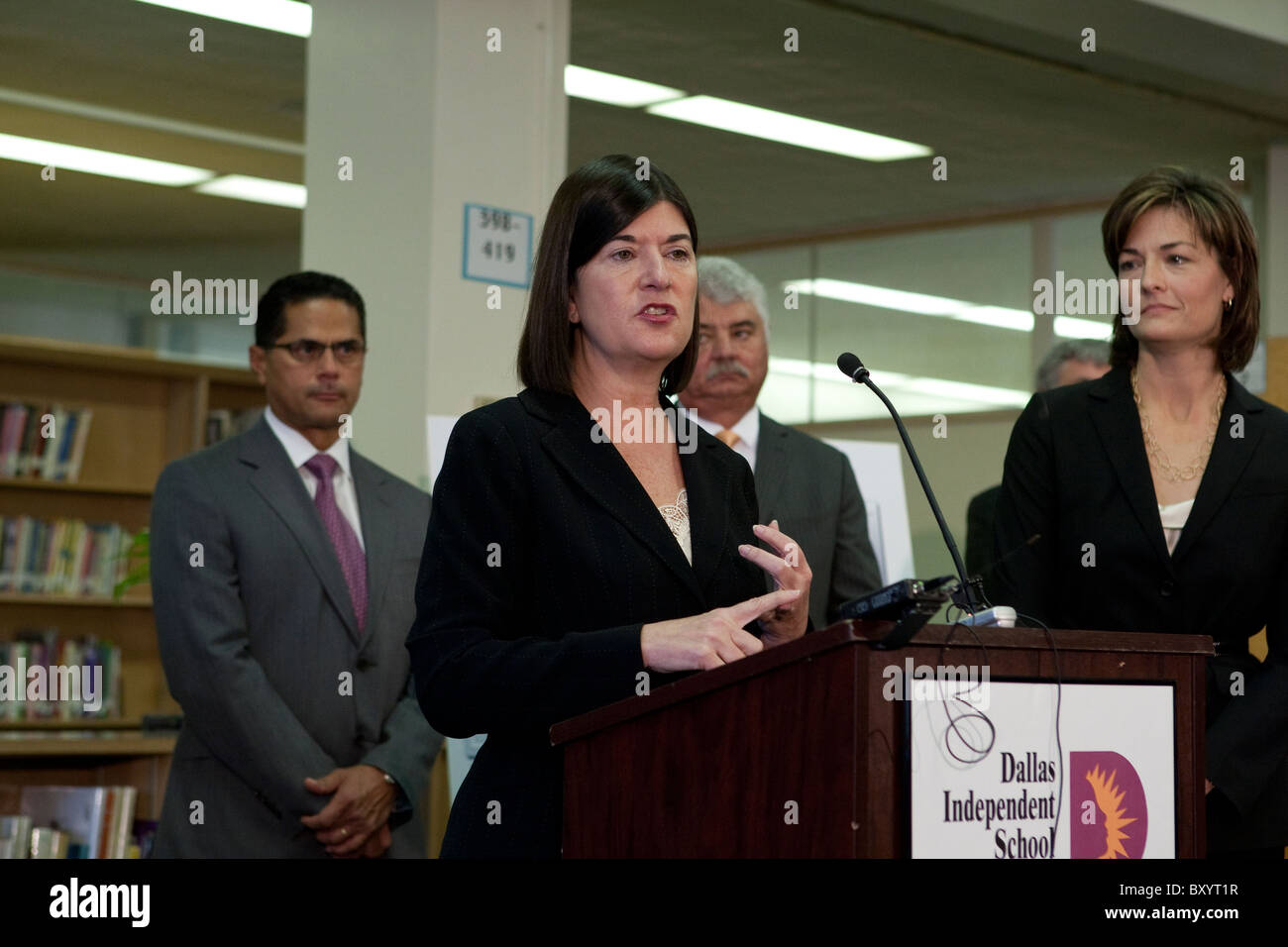 Female executive counts off talking points on her fingers at press conference at public school library in Dallas, Texas Stock Photo