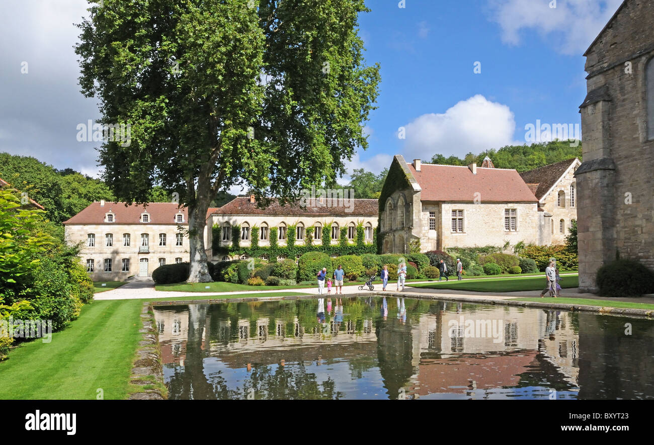 Abbot’s Lodging Refectory and Chapel with pool reflections and tourists at the Abbaye de Fontenay Burgundy France Stock Photo