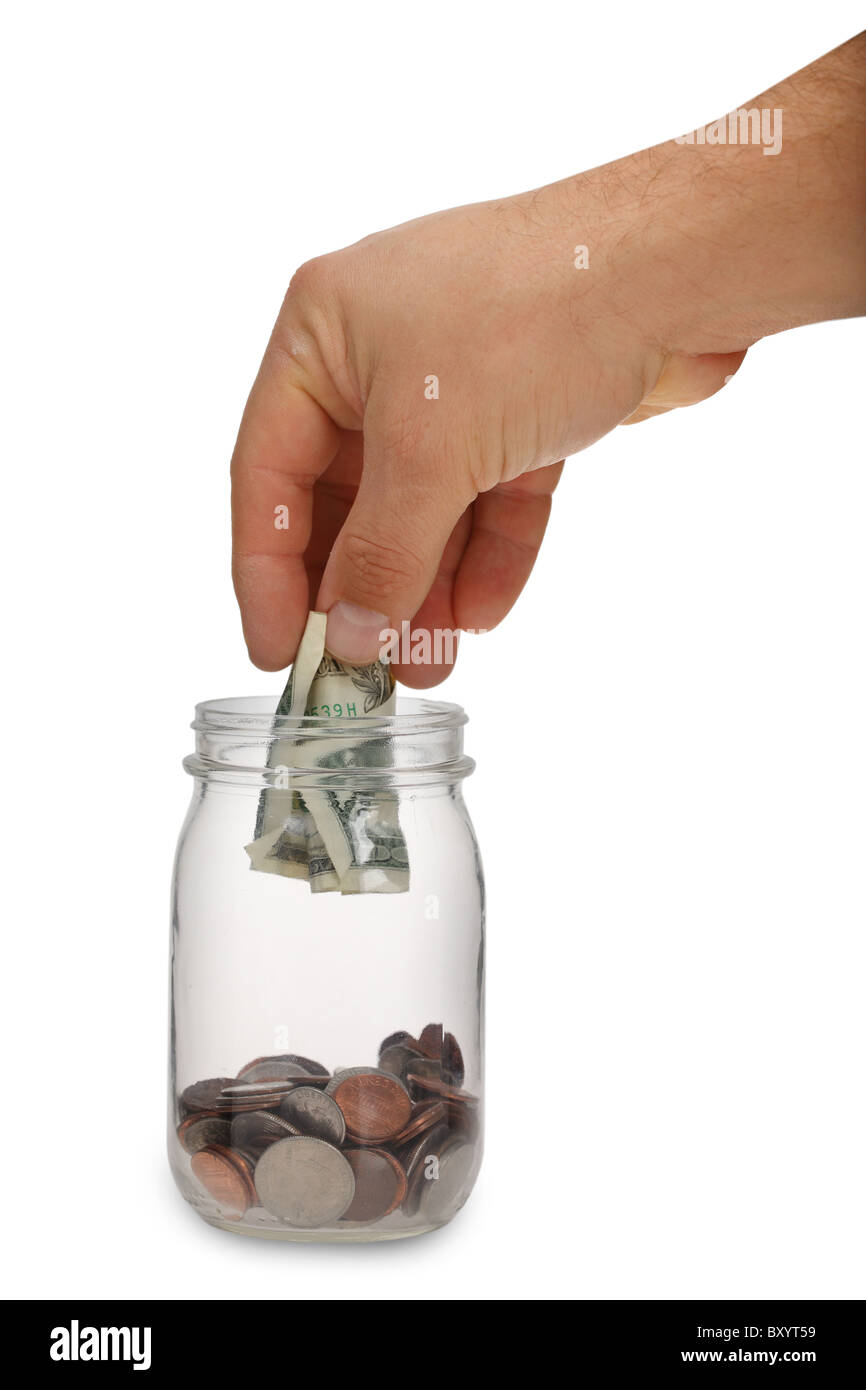 Hand putting money into jar on white background Stock Photo