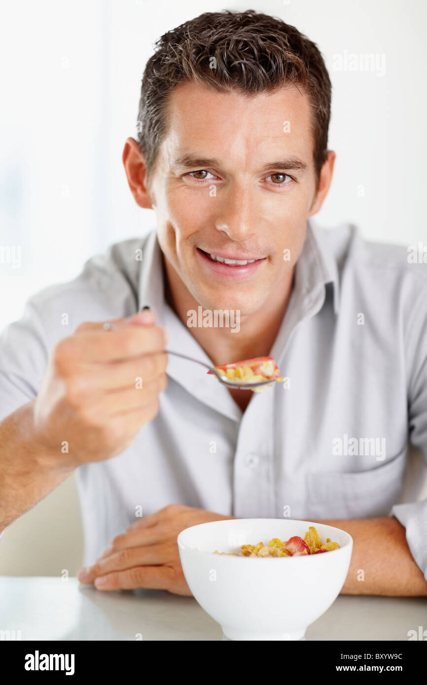 Cheerful mid adult man eating cornflakes Stock Photo - Alamy