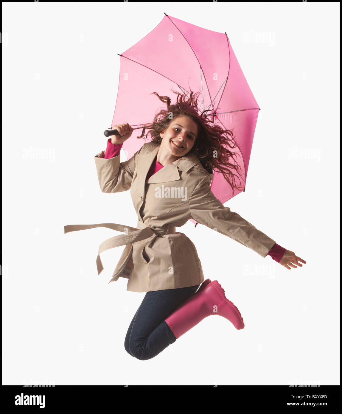 Woman with umbrella jumping on white background Stock Photo