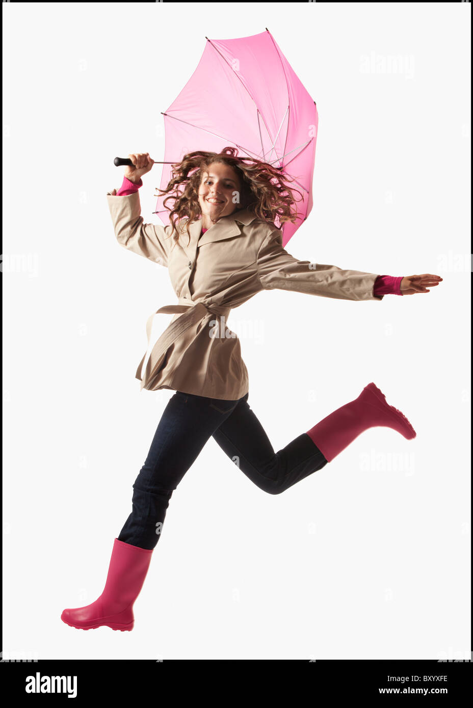 Woman with umbrella jumping on white background Stock Photo