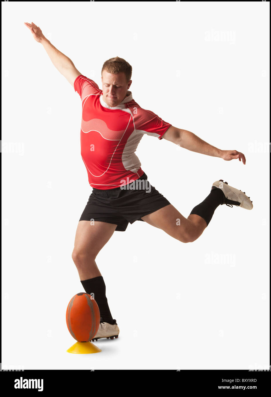 Male rugby player kicking ball Stock Photo