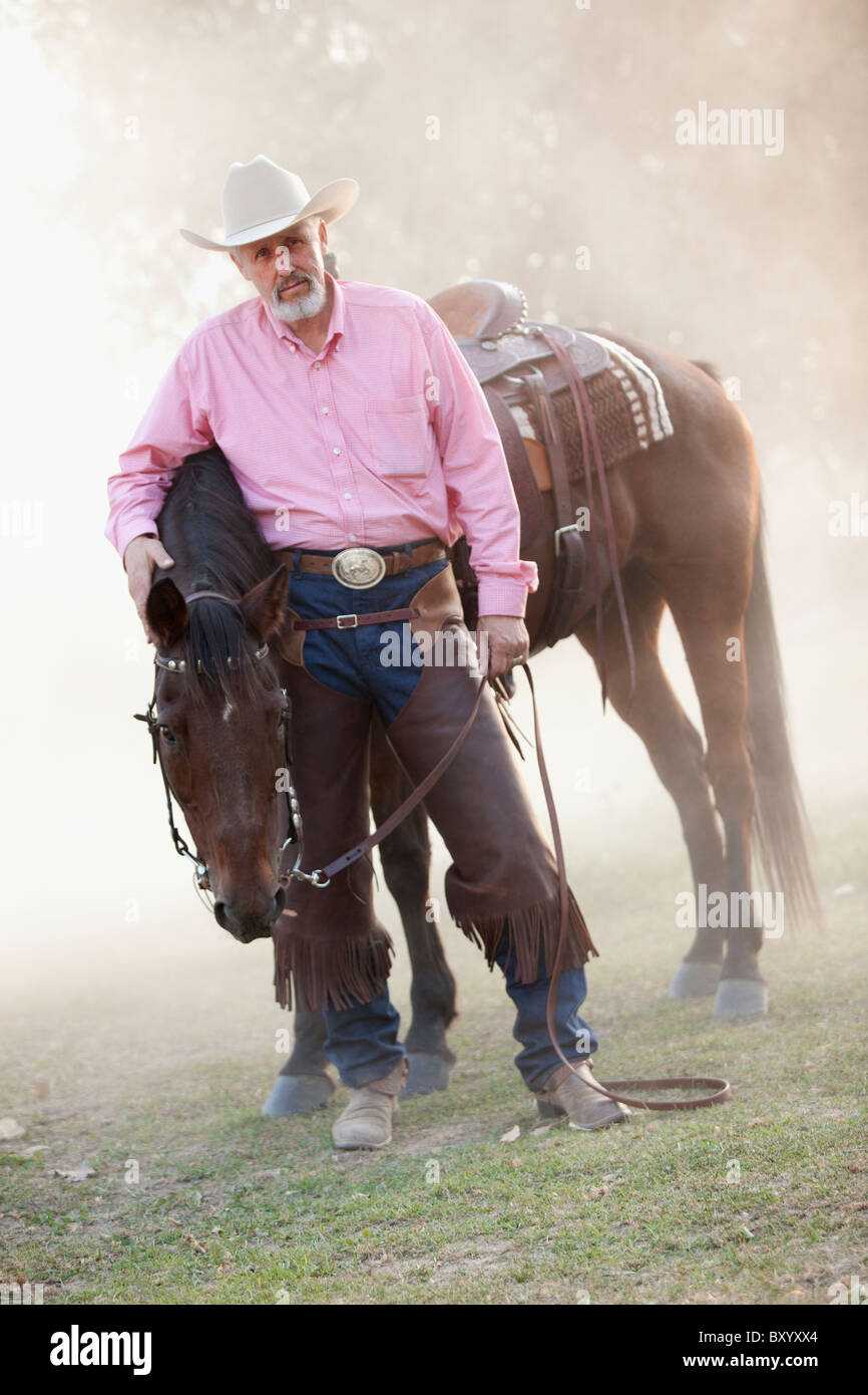 Portrait of senior man with horse in ranch Stock Photo