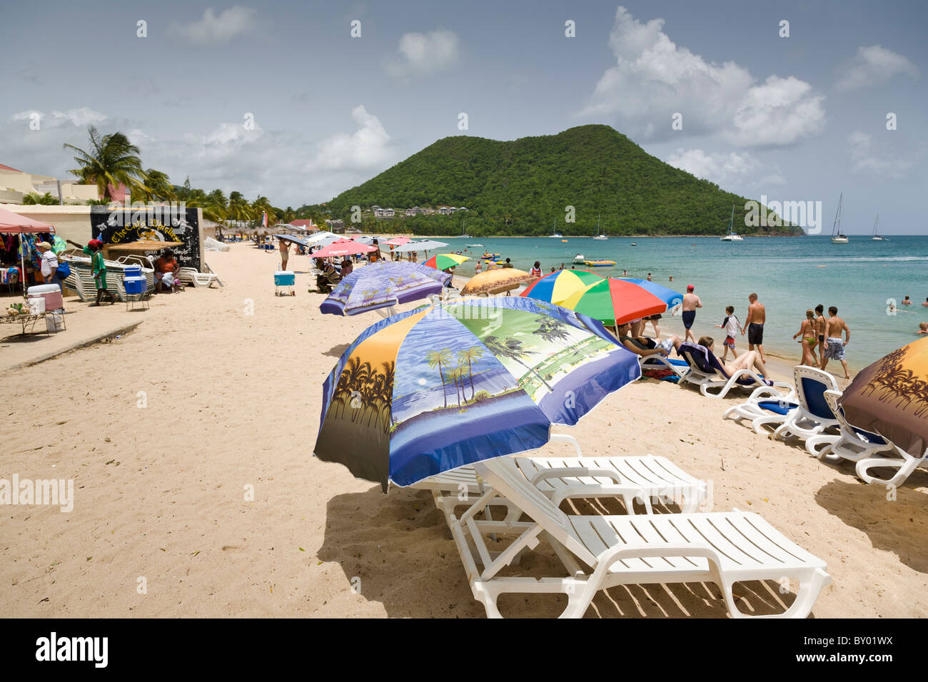 Sunloungers and sunbathers on the beach at Reduit Beach, St Lucia. Stock Photo