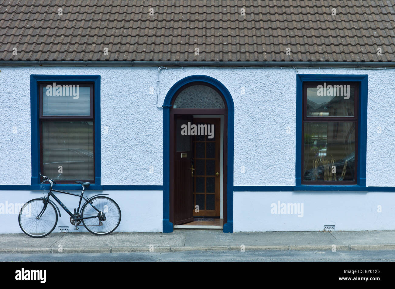 Street scene white pebbledash terraced bungalow and bicycle in Kilkee, County Clare, West of Ireland Stock Photo
