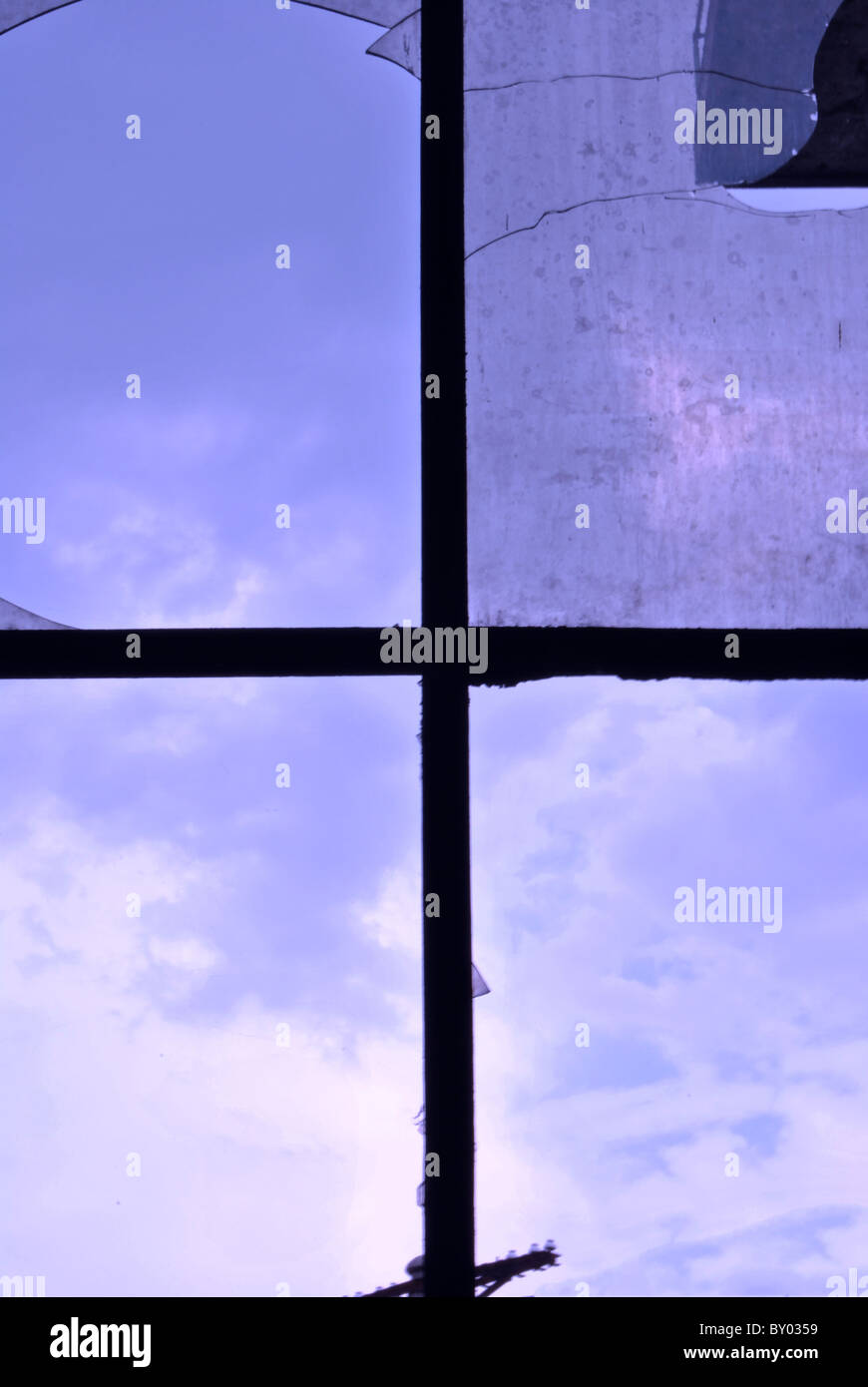 window with broken glass and the background blue sky with clouds Stock ...