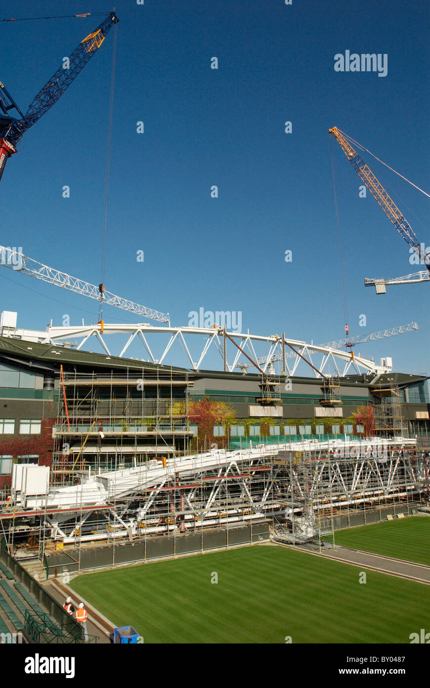 Two cranes work in tandem to lift roof trusses on to fixed roof of Centre Court, All England Lawn Tennis Club, Wimbledon, London Stock Photo