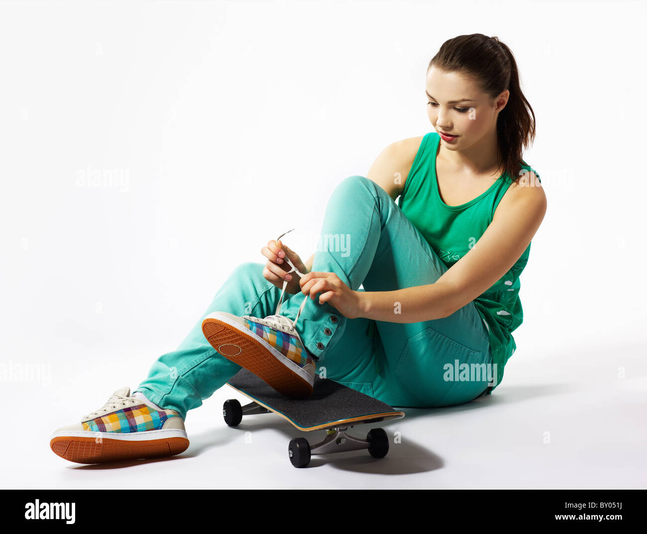 portrait of beautiful extreme girl with skateboard on gray Stock Photo