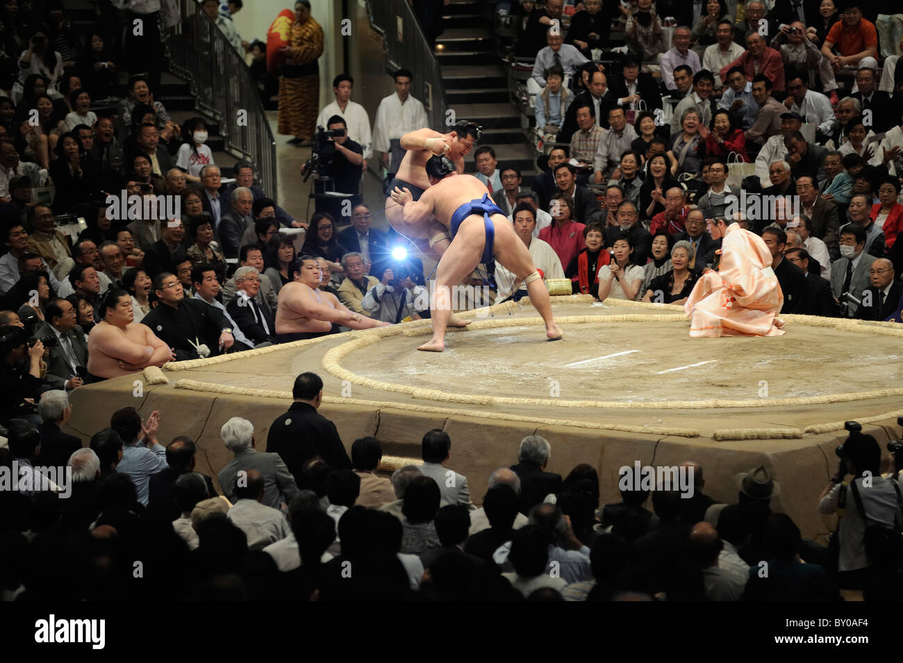 Sumo wrestler pushing opponent out of the ring, Grand Sumo Tournament