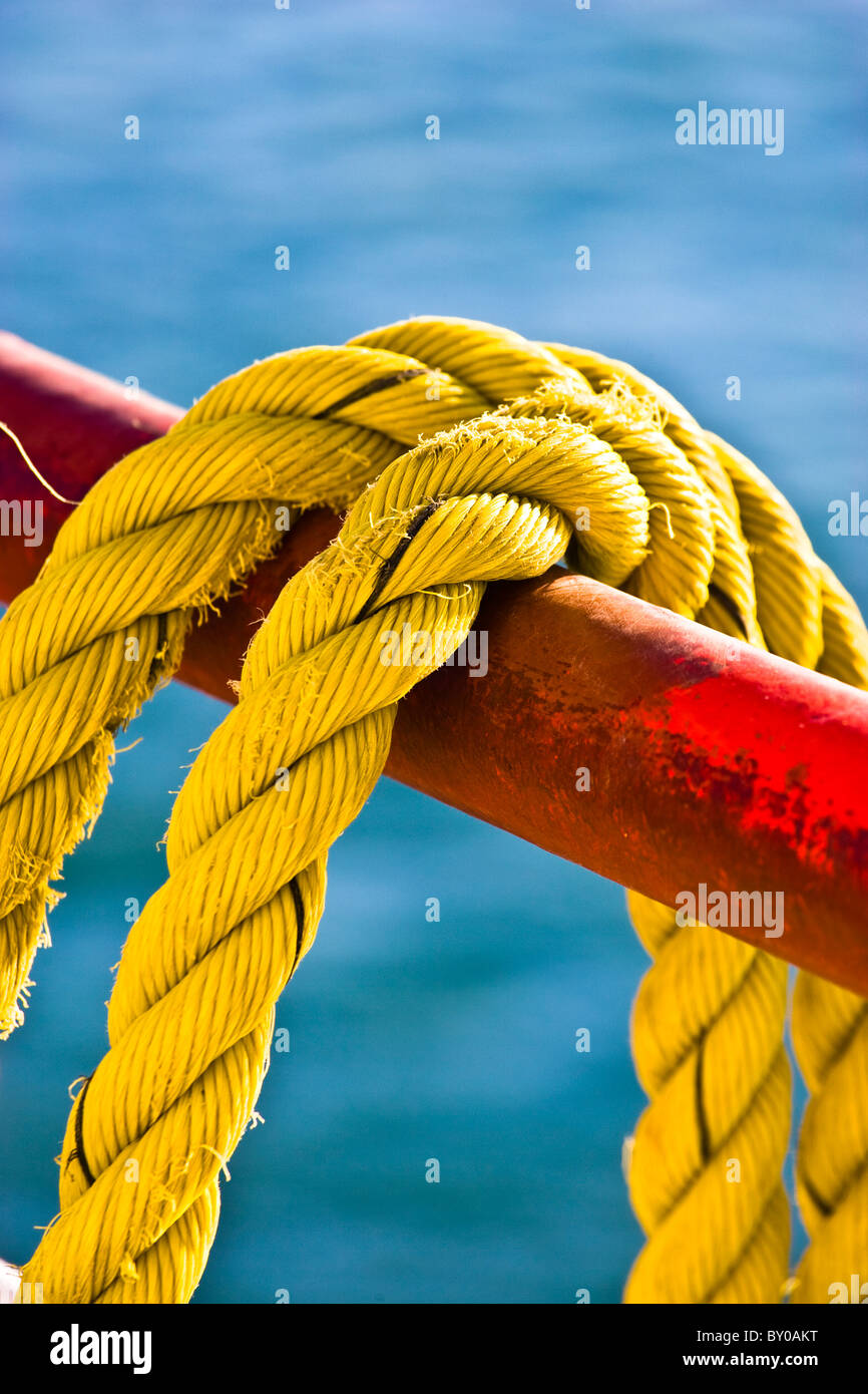 Yellow rope hanging on a red railing of a ferry boat. Stock Photo