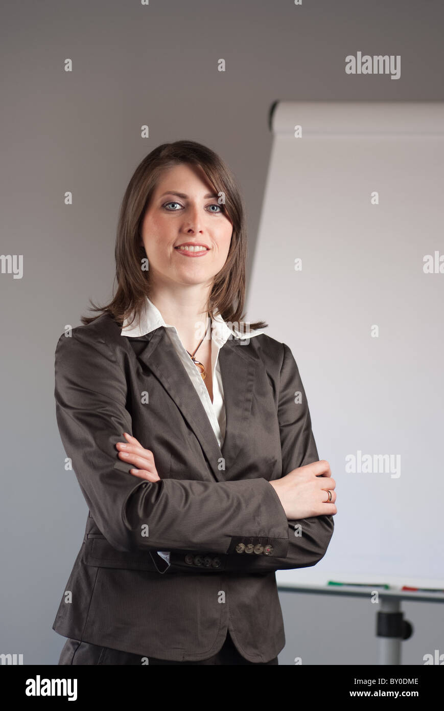 A young business woman standing in front of a flipchart Stock Photo