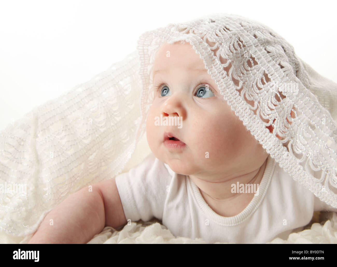 Portrait of an adorable baby with white blanket over head looking up