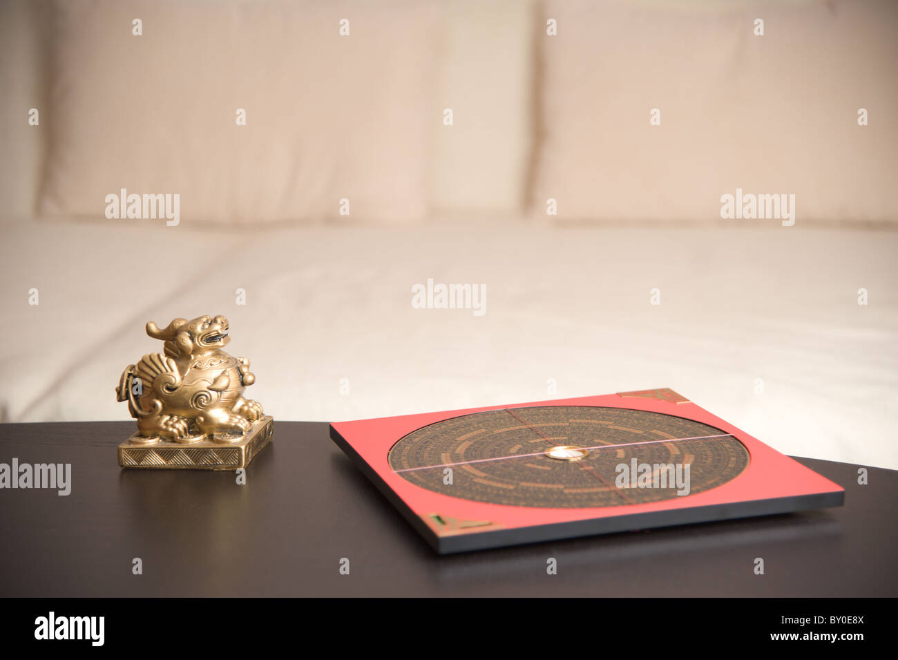 An asian figure and a Feng-Shui compass on a table Stock Photo