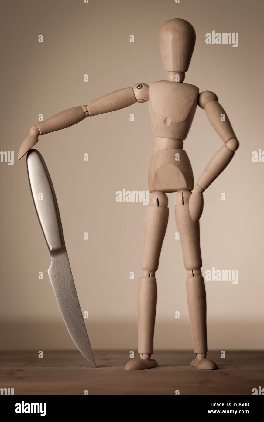 A wooden figure (jointed doll) posing with a knife Stock Photo