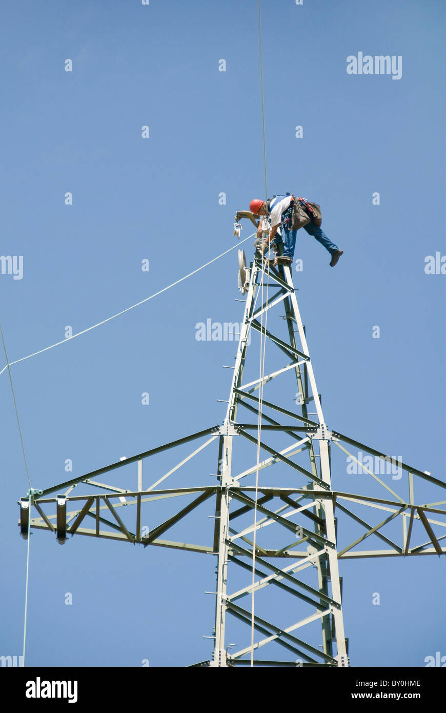 Worker on an electricity pylon attaching the cable, Austria, Europe Stock Photo