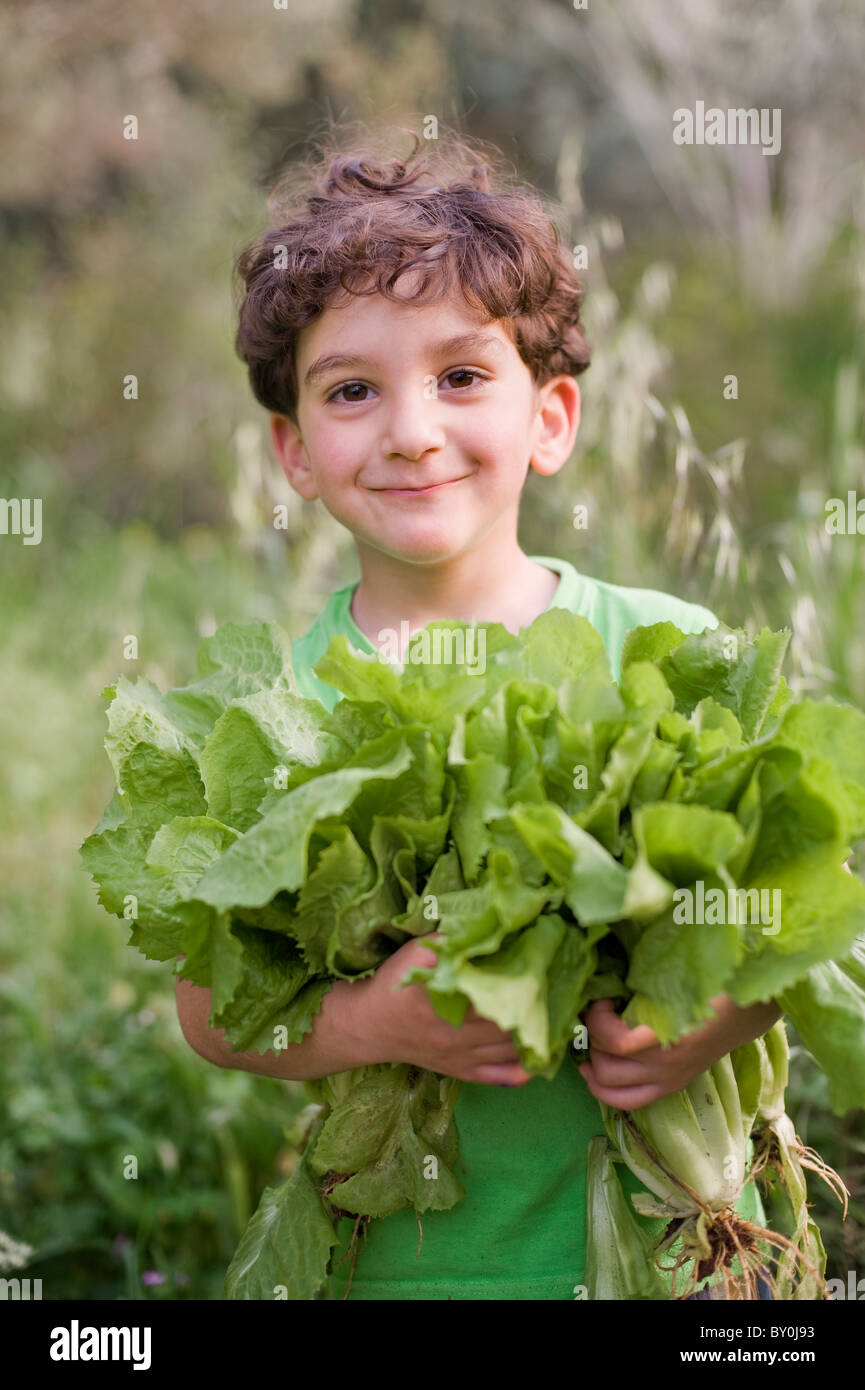boy holding organic lettuce outdoors Stock Photo