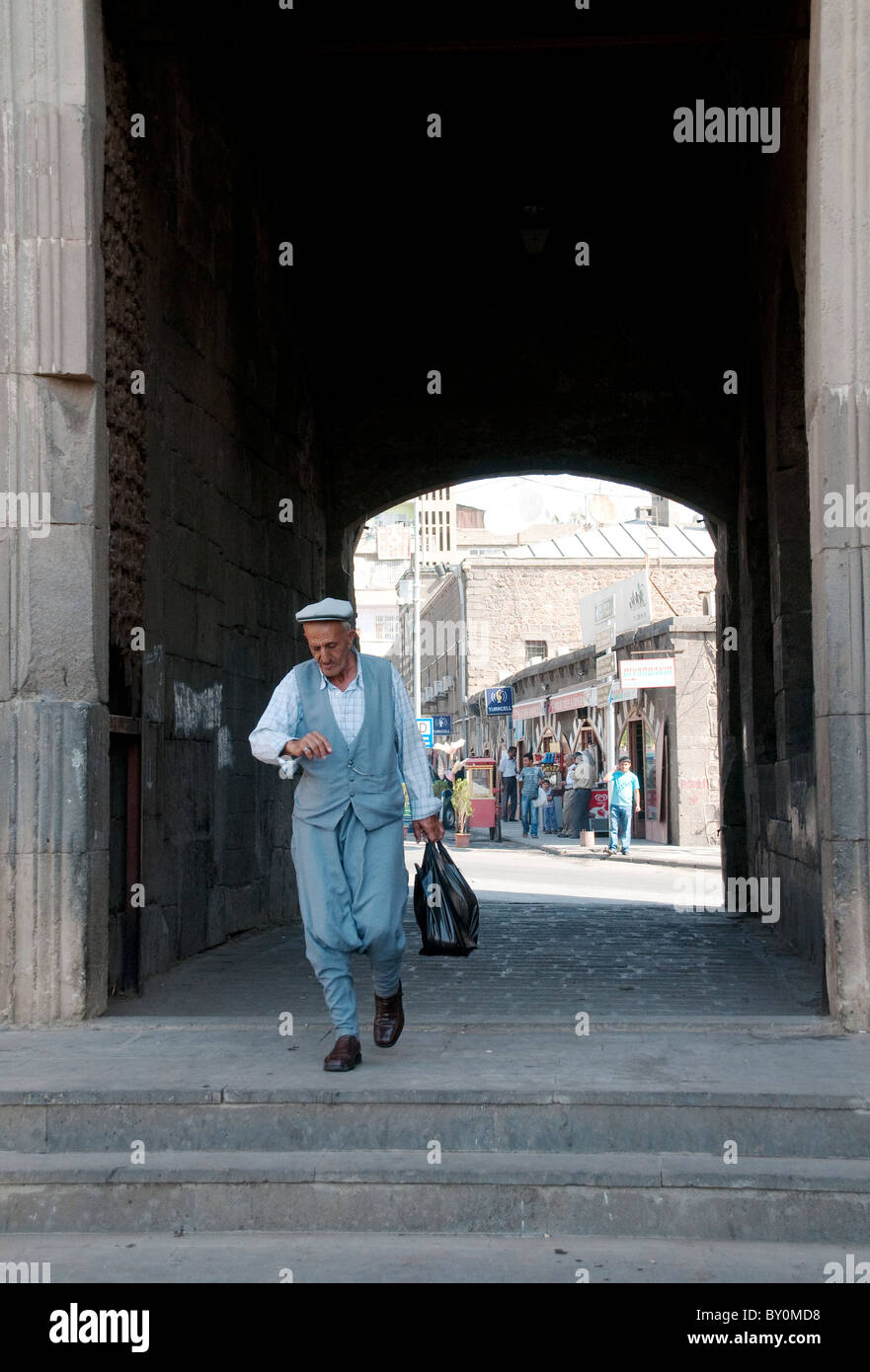 A Kurdish pedestrian walks through the Mardin Gate on the southern end of the old walls of the old city of Diyarbakir in Turkey. Stock Photo