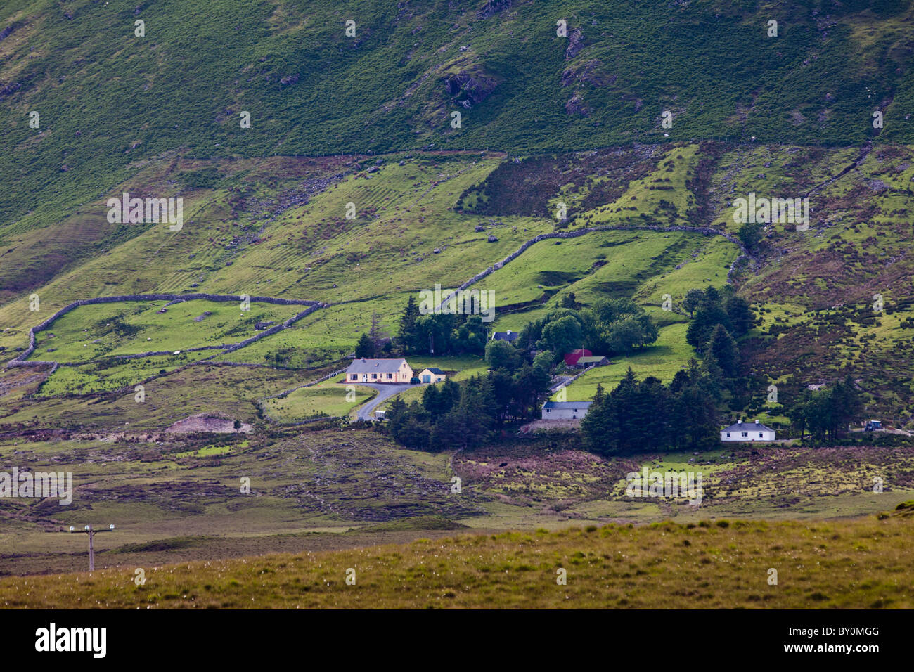 Homes nestling at the foot of the Twelve Bens mountain range in Connemara National Park, County Galway, Ireland Stock Photo