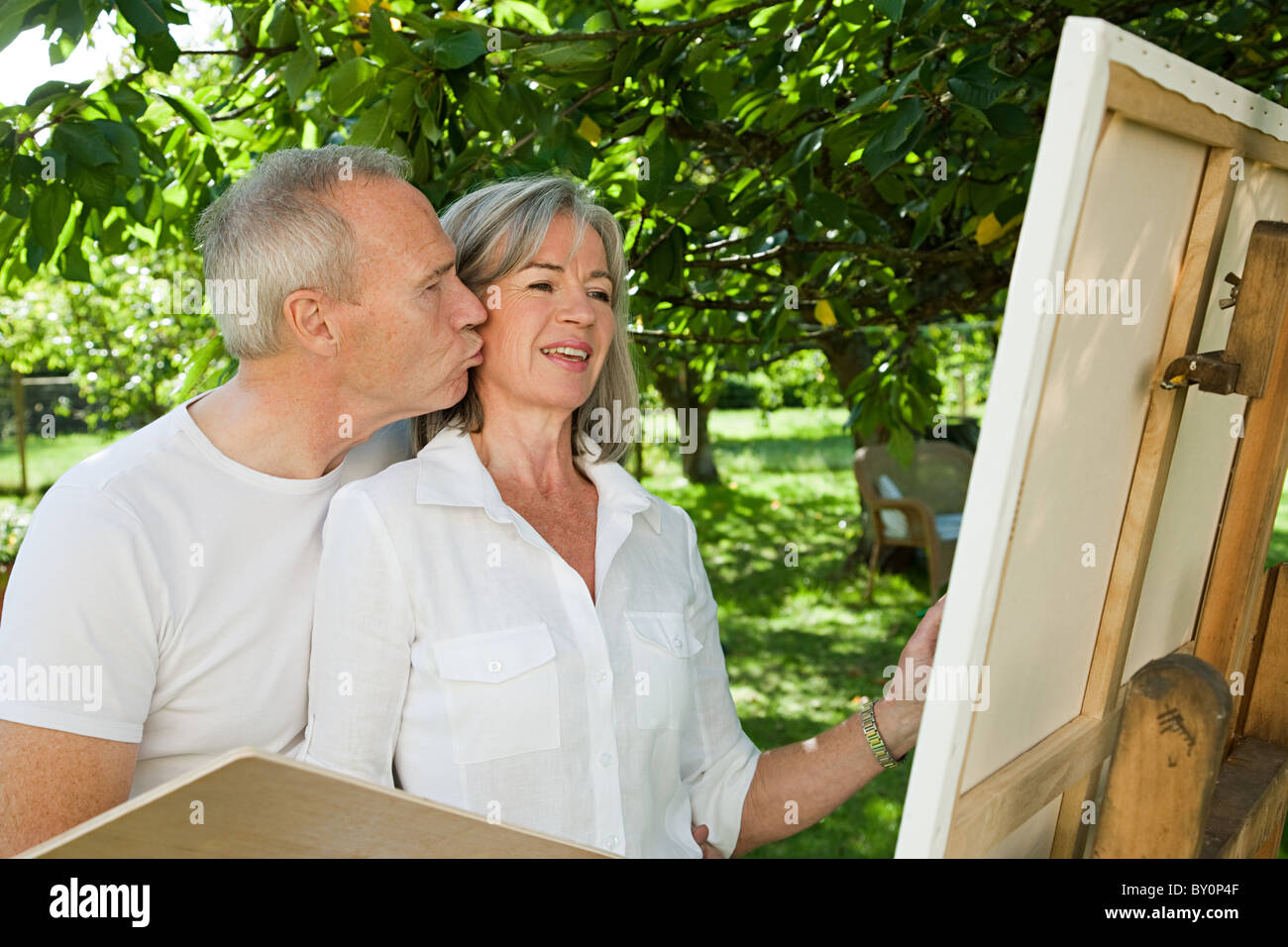 Mature couple, woman painting at easel Stock Photo