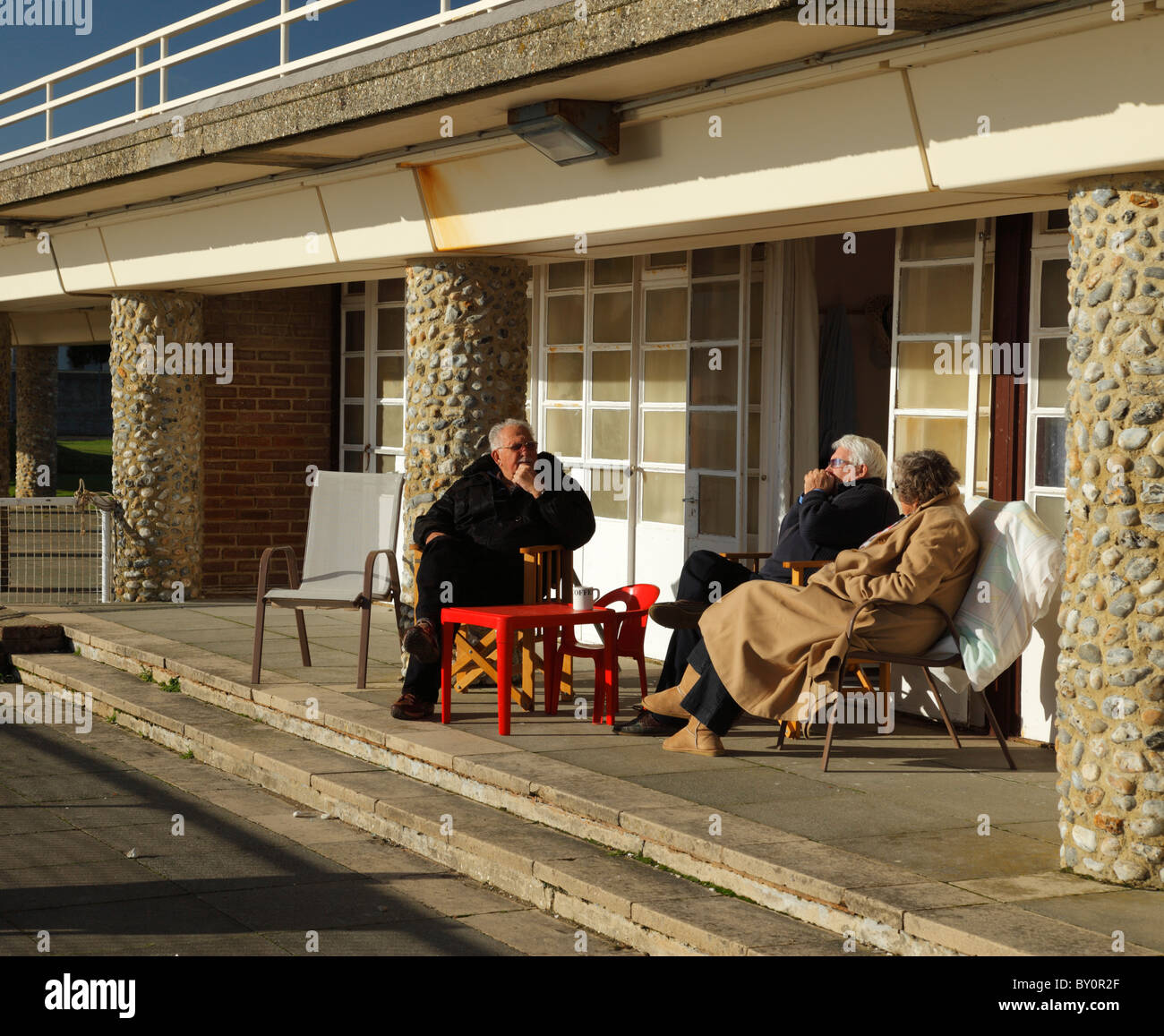People sitting outside their seaside chalet. Stock Photo