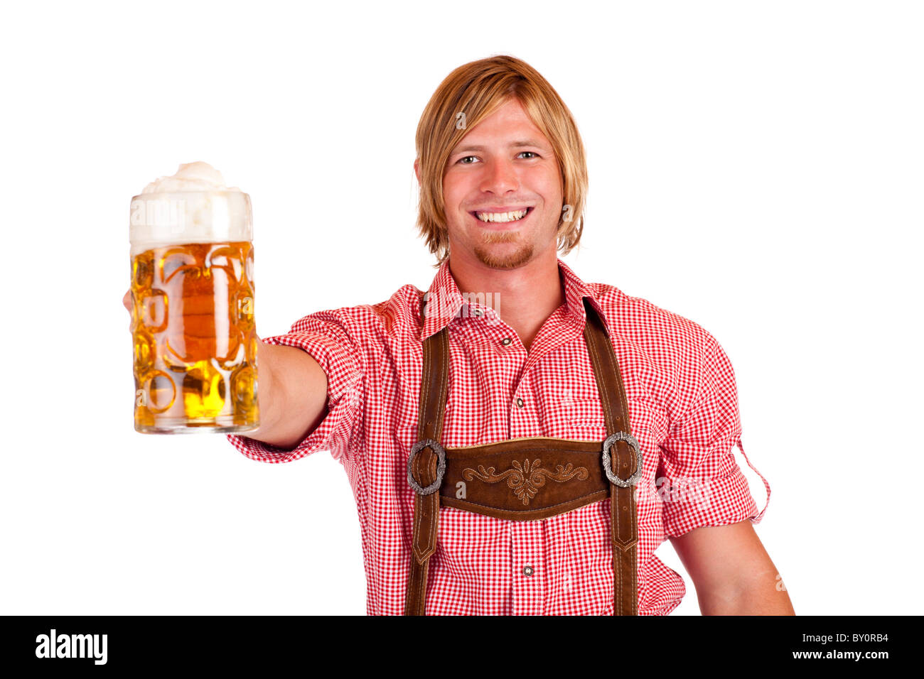 Happy smiling man with leather trousers (lederhose) holds oktoberfest beer stein. Isolated on white background. Stock Photo