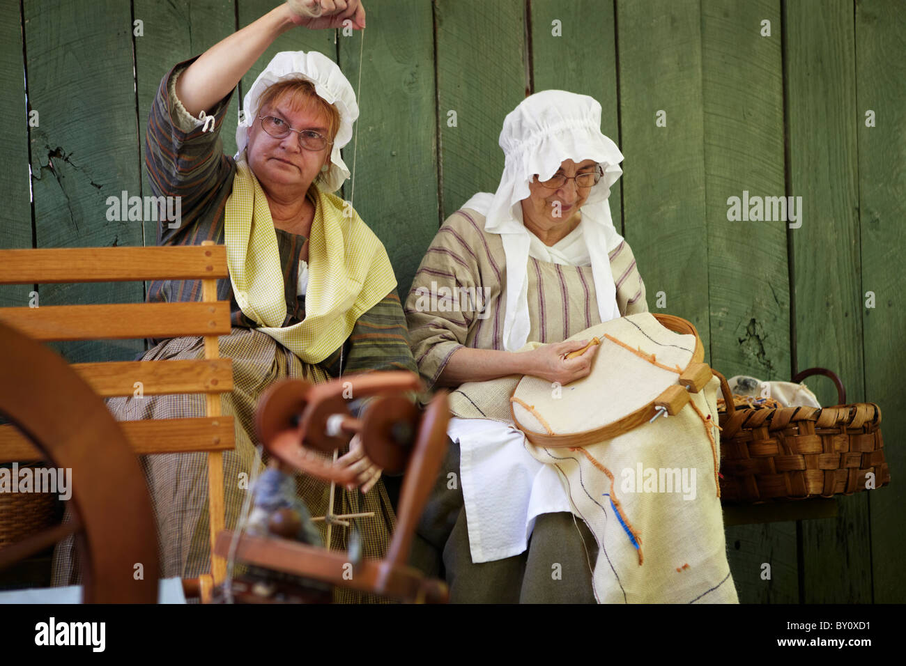 Two women sew at the Claude Moore Colonial Farm market fair, McLean, Virginia, where it is always 1771. Stock Photo