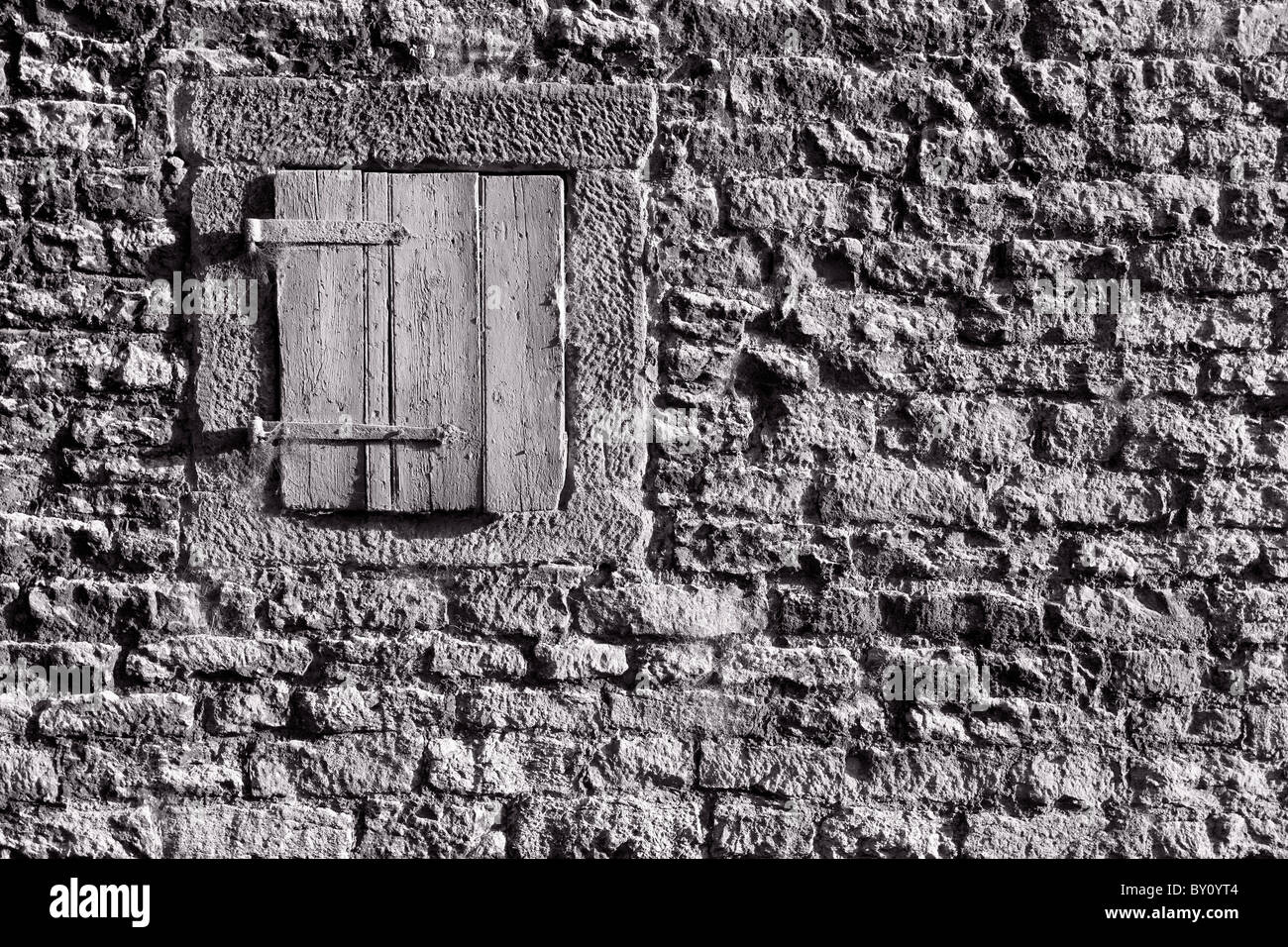 Shuttered window in the wall of a farm building Stock Photo