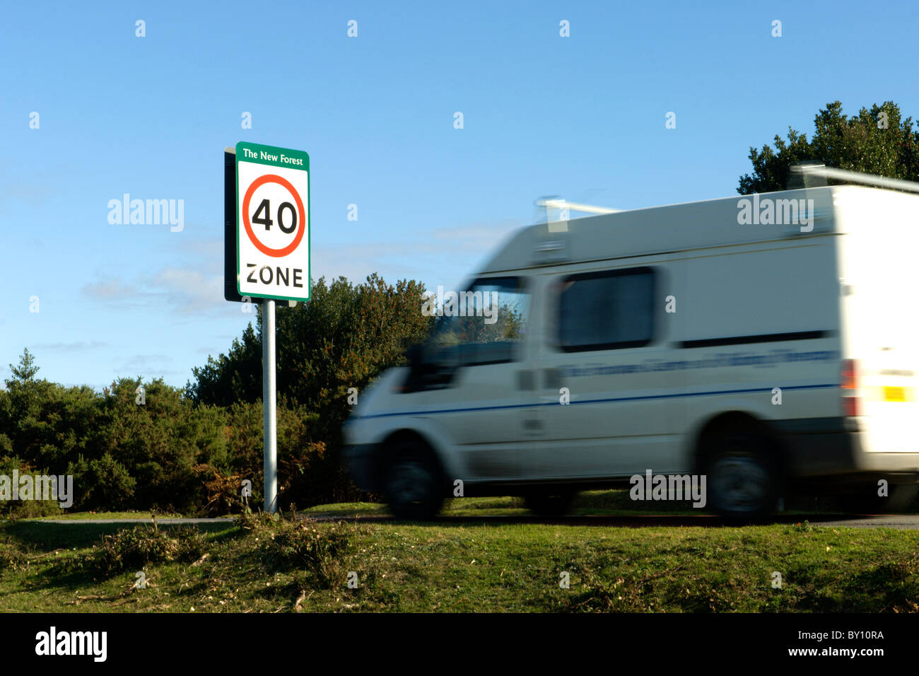 A white van approaching signage showing there is a 40 mph speed limit within the New Forest National Park Stock Photo