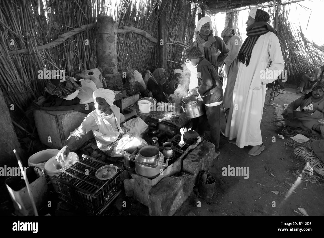Black and white image of men talking and tea drinking in rest area at Luxor Camel Market Egypt Africa Stock Photo