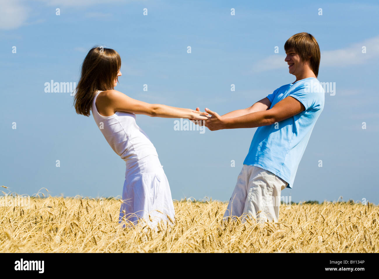 Мужчина и женщина стоят друг к другу и держаться за руки