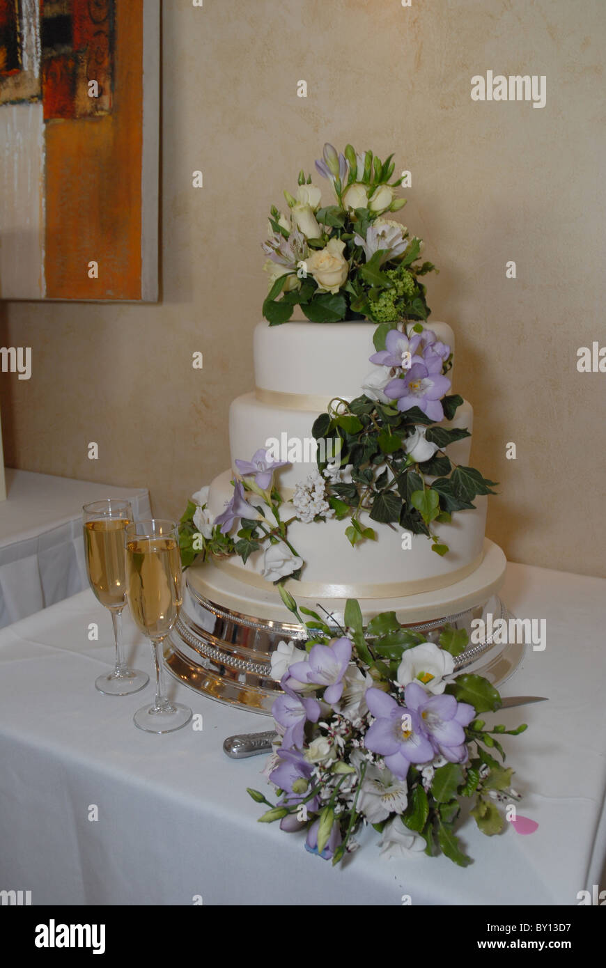 General View Of A White Wedding Cake With Champagne Flutes At